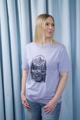 T-Shirt aus 100 % Bio-Baumwolle mit normaler Passform, erhältlich in verschiedenen Farben wie Blue Soul, Cotton Pink, Lavender, Aloe, Weiss und Schwarz. Individuell bedruckbar mit Wunschmotiv. Weiches, angenehm leichtes Material für hohen Tragekomfort. Ideal für einen zeitgemässen, entspannten Look. Mit schwarzer Kamera-Illustration, Bergpanorama und Tannenwäldern auf der Vorderseite des T-Shirts.