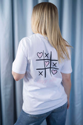 T-Shirt aus 100 % Bio-Baumwolle mit normaler Passform, erhältlich in verschiedenen Farben wie Blue Soul, Cotton Pink, Lavender, Aloe, Weiss und Schwarz. Individuell bedruckbar mit Wunschmotiv. Weiches, angenehm leichtes Material für hohen Tragekomfort. Ideal für einen zeitgemässen, entspannten Look. Vorderseite: Rosa Herz auf der linken Brust. Rückseite: Tic-Tac-Toe-Motiv mit rosa Herzen und darunter der Schriftzug „LOVE WINS“ in rosa.