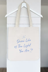 Nachhaltige Tote Bag in Natural Raw mit blauem Print Shine Like The Light You Are.