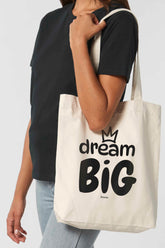 Naturfarbene Tote Bag mit schwarzem Aufdruck „dream BIG“ und kleiner Krone über dem Schriftzug – stilvolles Statement-Piece aus 80% recycelter Baumwolle und 20% recyceltem Polyester, fair produziert.