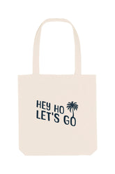 Naturfarbene Tote Bag mit schwarzem Schriftzug „HEY HO LET’S GO“ und Palmenmotiv – nachhaltige Stofftasche aus recycelten Materialien mit langen Henkeln und geräumigem Schnitt.