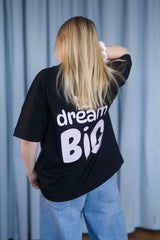 Oversized T-Shirt aus 100 % Bio-Baumwolle mit weitem, modernem Schnitt, erhältlich in Schwarz, Weiss und Natur. Individuell gestaltbar mit Wunschmotiv und frei wählbarer Platzierung. Weiche Qualität, überschnittene Ärmelansätze und lässiger Style für maximalen Tragekomfort. Vorderseite: Krone auf der linken Brust. Rückseite: Grosser Schriftzug „dream BIG“ mit Krone darüber.