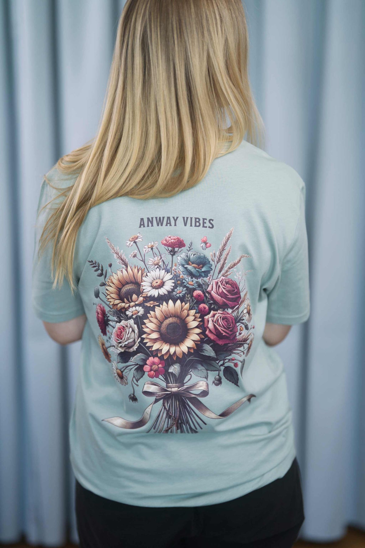 T-Shirt aus 100 % Bio-Baumwolle mit normaler Passform, erhältlich in verschiedenen Farben wie Blue Soul, Cotton Pink, Lavender, Aloe, Weiss und Schwarz. Individuell bedruckbar mit Wunschmotiv. Weiches, angenehm leichtes Material für hohen Tragekomfort. Ideal für einen zeitgemässen, entspannten Look. Mit grossem buntem Blumenstrauss auf dem Rücken und „ANWAY VIBES“-Schriftzug.