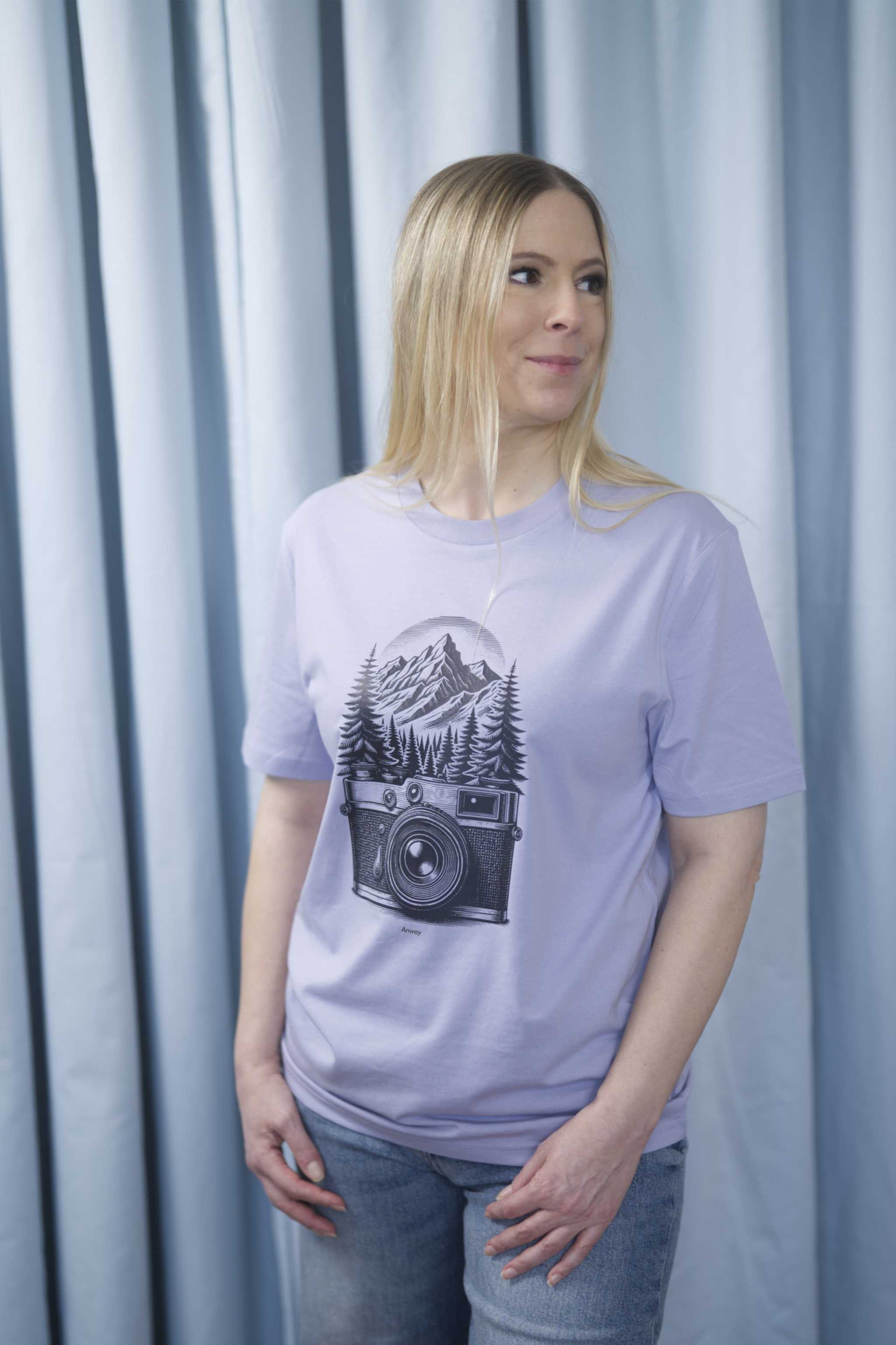 T-Shirt aus 100 % Bio-Baumwolle mit normaler Passform, erhältlich in verschiedenen Farben wie Blue Soul, Cotton Pink, Lavender, Aloe, Weiss und Schwarz. Individuell bedruckbar mit Wunschmotiv. Weiches, angenehm leichtes Material für hohen Tragekomfort. Ideal für einen zeitgemässen, entspannten Look. Mit schwarzer Kamera-Illustration, Bergpanorama und Tannenwäldern auf der Vorderseite des T-Shirts.
