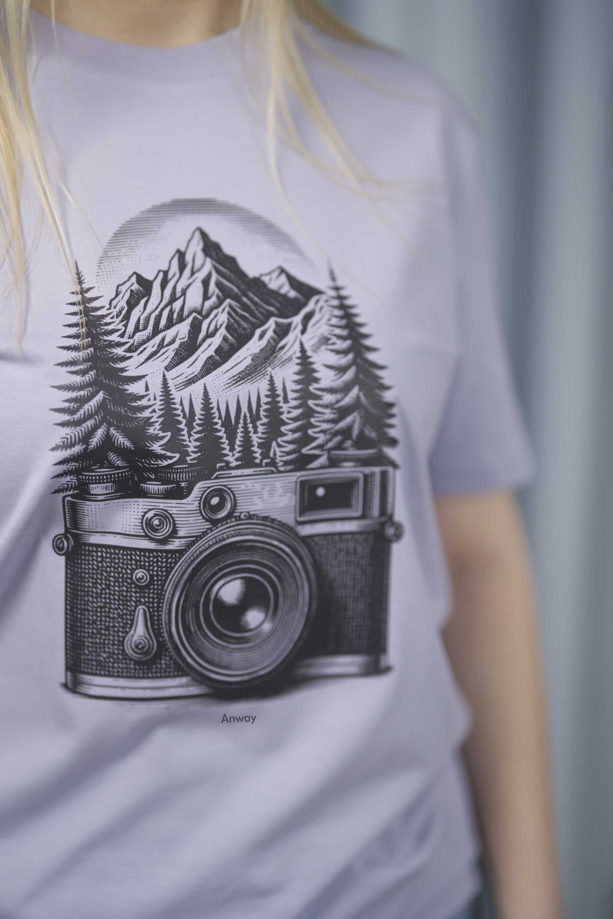 T-Shirt aus 100 % Bio-Baumwolle mit normaler Passform, erhältlich in verschiedenen Farben wie Blue Soul, Cotton Pink, Lavender, Aloe, Weiss und Schwarz. Individuell bedruckbar mit Wunschmotiv. Weiches, angenehm leichtes Material für hohen Tragekomfort. Ideal für einen zeitgemässen, entspannten Look. Mit schwarzer Kamera-Illustration, Bergpanorama und Tannenwäldern auf der Vorderseite des T-Shirts.