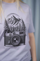 T-Shirt aus 100 % Bio-Baumwolle mit normaler Passform, erhältlich in verschiedenen Farben wie Blue Soul, Cotton Pink, Lavender, Aloe, Weiss und Schwarz. Individuell bedruckbar mit Wunschmotiv. Weiches, angenehm leichtes Material für hohen Tragekomfort. Ideal für einen zeitgemässen, entspannten Look. Mit schwarzer Kamera-Illustration, Bergpanorama und Tannenwäldern auf der Vorderseite des T-Shirts.