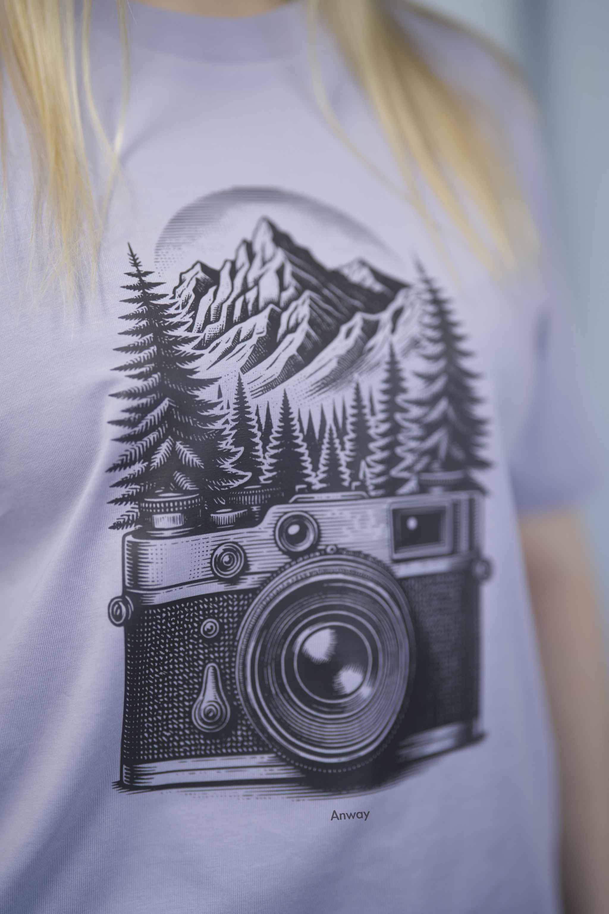 T-Shirt aus 100 % Bio-Baumwolle mit normaler Passform, erhältlich in verschiedenen Farben wie Blue Soul, Cotton Pink, Lavender, Aloe, Weiss und Schwarz. Individuell bedruckbar mit Wunschmotiv. Weiches, angenehm leichtes Material für hohen Tragekomfort. Ideal für einen zeitgemässen, entspannten Look. Mit schwarzer Kamera-Illustration, Bergpanorama und Tannenwäldern auf der Vorderseite des T-Shirts.