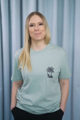T-Shirt aus 100 % Bio-Baumwolle mit normaler Passform, erhältlich in verschiedenen Farben wie Blue Soul, Cotton Pink, Lavender, Aloe, Weiss und Schwarz. Individuell bedruckbar mit Wunschmotiv. Weiches, angenehm leichtes Material für hohen Tragekomfort. Ideal für einen zeitgemässen, entspannten Look. T-Shirt mit kleinem Motiv einer Palme und eines Liegestuhls auf der linken Brust und einem detaillierten Strandmotiv mit Palmen, Kokosnüssen und Sonnenuntergang auf der Rückseite. 