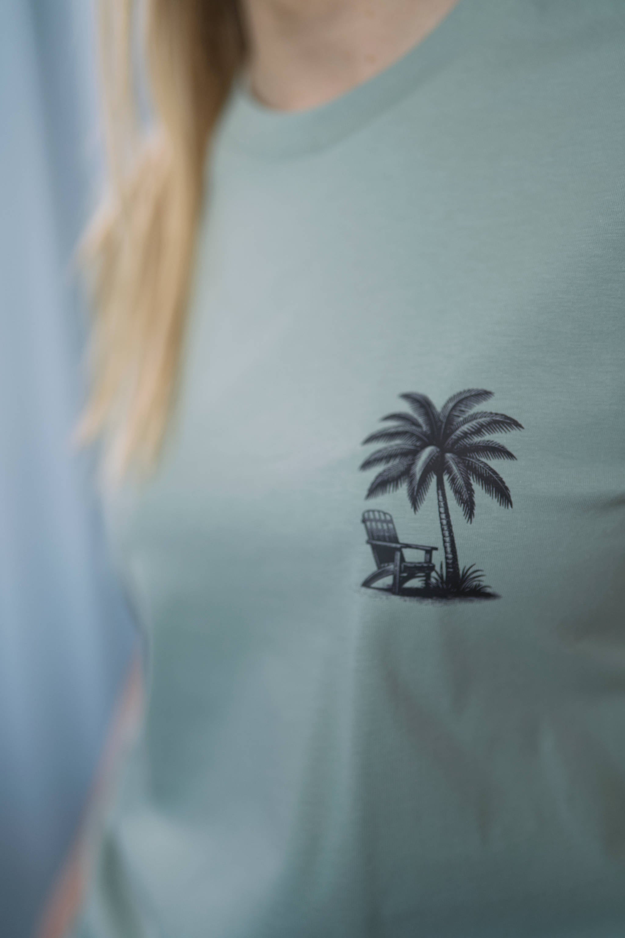 T-Shirt aus 100 % Bio-Baumwolle mit normaler Passform, erhältlich in verschiedenen Farben wie Blue Soul, Cotton Pink, Lavender, Aloe, Weiss und Schwarz. Individuell bedruckbar mit Wunschmotiv. Weiches, angenehm leichtes Material für hohen Tragekomfort. Ideal für einen zeitgemässen, entspannten Look. T-Shirt mit kleinem Motiv einer Palme und eines Liegestuhls auf der linken Brust und einem detaillierten Strandmotiv mit Palmen, Kokosnüssen und Sonnenuntergang auf der Rückseite. 