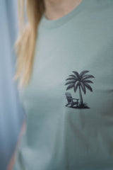 T-Shirt aus 100 % Bio-Baumwolle mit normaler Passform, erhältlich in verschiedenen Farben wie Blue Soul, Cotton Pink, Lavender, Aloe, Weiss und Schwarz. Individuell bedruckbar mit Wunschmotiv. Weiches, angenehm leichtes Material für hohen Tragekomfort. Ideal für einen zeitgemässen, entspannten Look. T-Shirt mit kleinem Motiv einer Palme und eines Liegestuhls auf der linken Brust und einem detaillierten Strandmotiv mit Palmen, Kokosnüssen und Sonnenuntergang auf der Rückseite. 