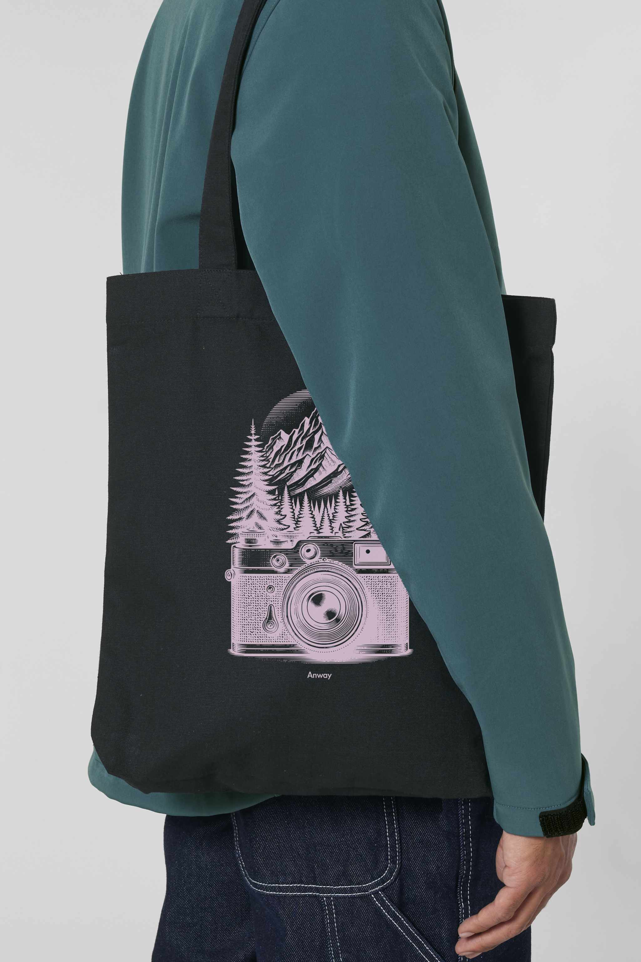 Schwarze Tote Bag mit rosa Vintage-Motiv einer analogen, alten Kamera vor einem Bergpanorama und Tannen – hochwertige Stofftasche aus 80% recycelter Baumwolle und 20% recyceltem Polyester, ideal für Natur- und Fotografie-Liebhaber.
