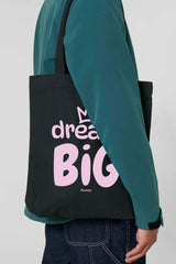 Schwarze Tote Bag mit rosa Aufdruck „dream BIG“ und kleiner Krone über dem Schriftzug – stilvolles Statement-Piece aus 80% recycelter Baumwolle und 20% recyceltem Polyester, fair produziert.