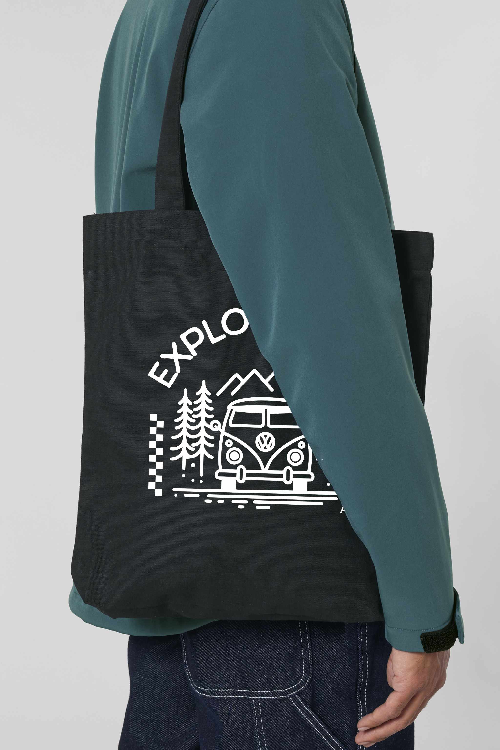 Schwarze Tote Bag mit weissem Aufdruck „EXPLORER GIRL“ – illustriert mit einem VW-Bus, Tannenbäumen und Bergen – robustes, stylisches Accessoire aus 80% recycelter Baumwolle und 20% recyceltem Polyester, fair produziert.