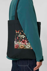 Schwarze Tote Bag mit farbiger Blumenwiese und Schmetterlingen – stilvoller, nachhaltiger Stoffbeutel aus 80% recycelter Baumwolle und 20% recyceltem Polyester, mit robusten Nähten und langen Henkeln.