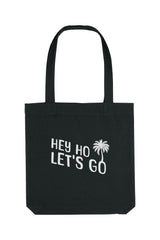 Schwarze Tote Bag mit weissem Schriftzug „HEY HO LET’S GO“ und Palmenmotiv – nachhaltige Stofftasche aus recycelten Materialien mit langen Henkeln und geräumigem Schnitt.