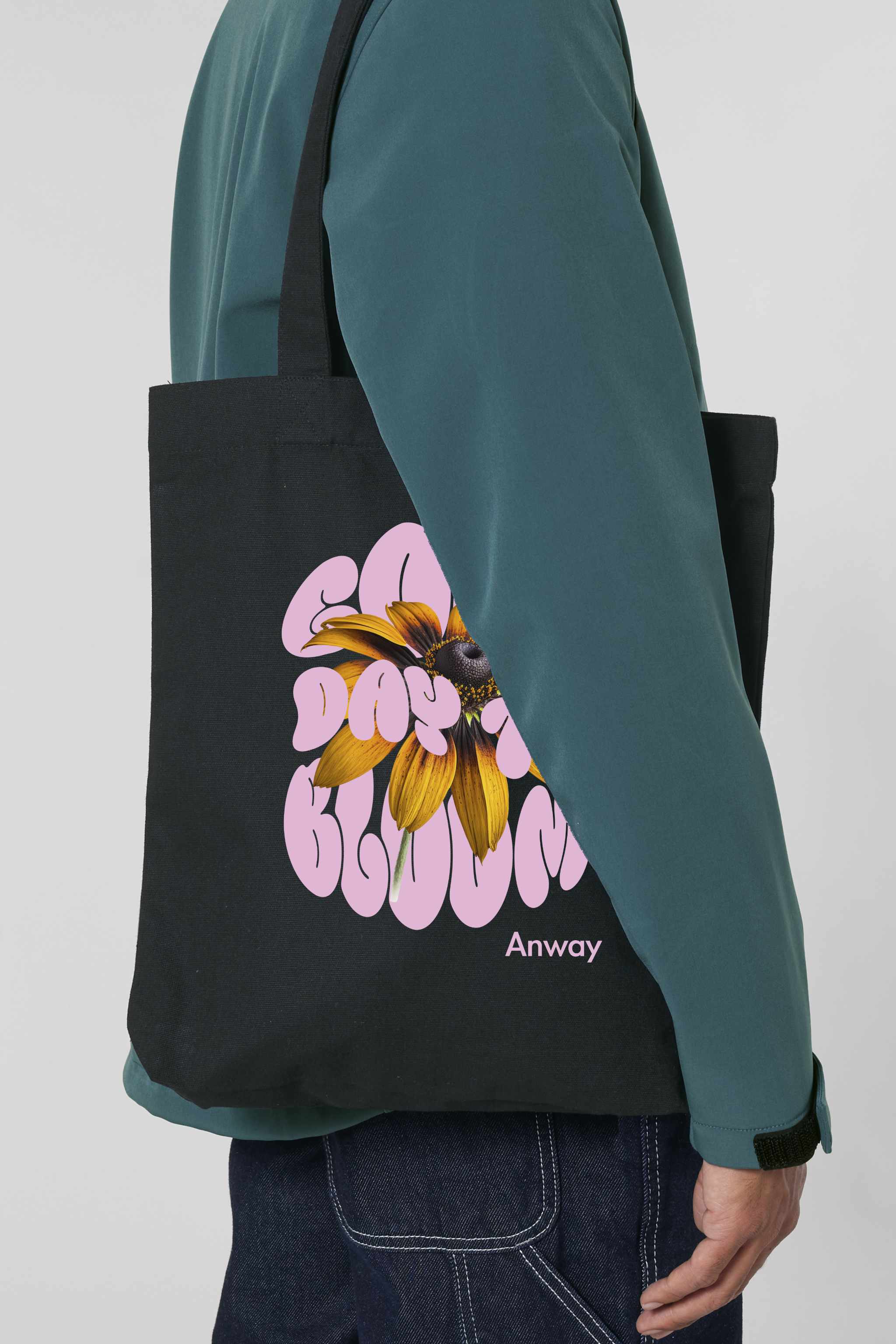 Schwarze Tote Bag mit dem rosa Schriftzug „GOOD DAY TO BLOOM“ im Retro-Stil, durchzogen von einer leuchtend gelben Sonnenblume – florales Statement-Piece mit positiver Botschaft.