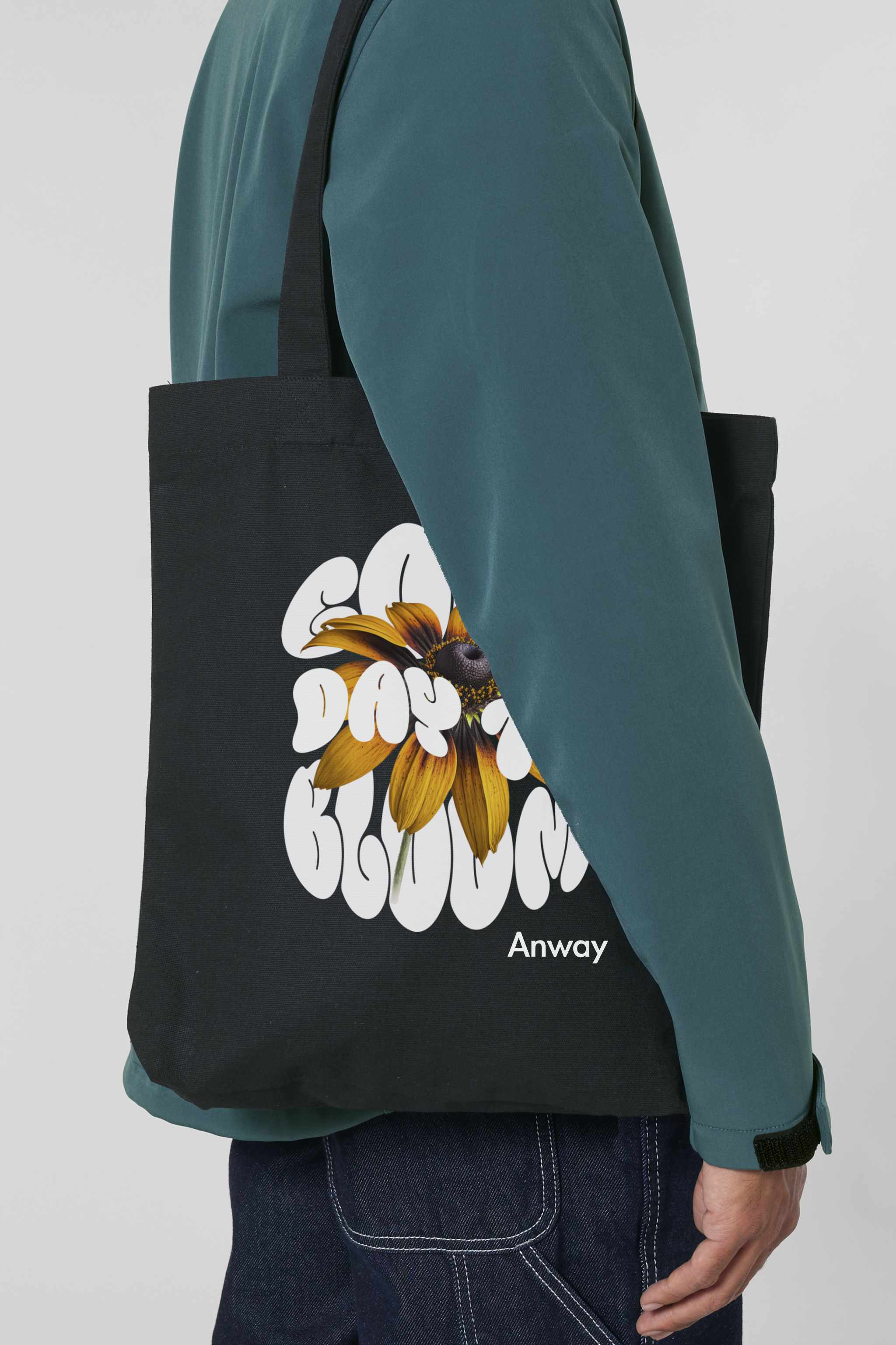 Schwarze Tote Bag mit dem weissen Schriftzug „GOOD DAY TO BLOOM“ im Retro-Stil, durchzogen von einer leuchtend gelben Sonnenblume – florales Statement-Piece mit positiver Botschaft.