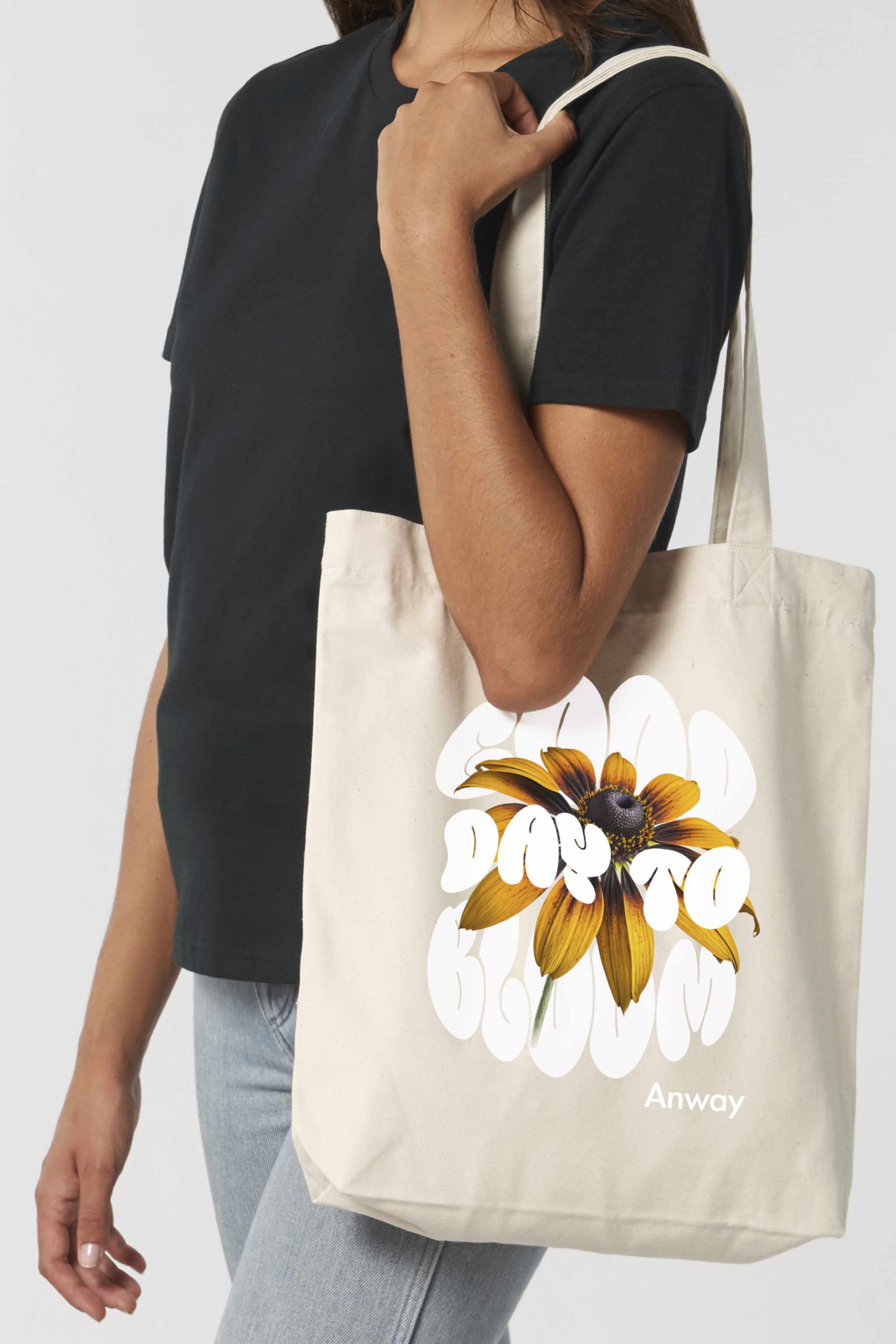 Naturfarbene Tote Bag mit dem weissem Schriftzug „GOOD DAY TO BLOOM“ im Retro-Stil, durchzogen von einer leuchtend gelben Sonnenblume – florales Statement-Piece mit positiver Botschaft.