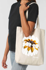 Naturfarbene Tote Bag mit dem weissem Schriftzug „GOOD DAY TO BLOOM“ im Retro-Stil, durchzogen von einer leuchtend gelben Sonnenblume – florales Statement-Piece mit positiver Botschaft.