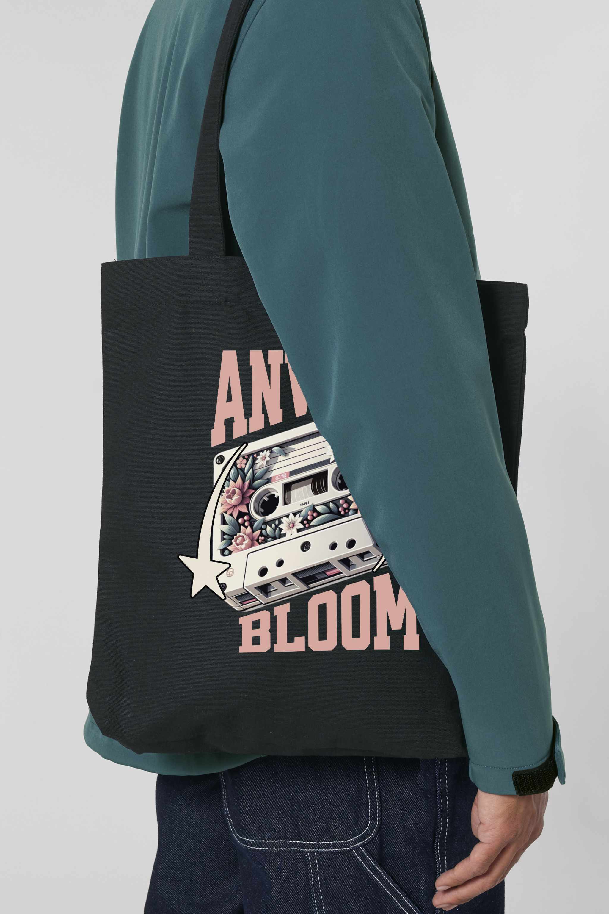Schwarze Tote Bag mit retro-inspiriertem Design: Eine Kassette mit floralen Elementen, flankiert von zwei Sternen, und dem Schriftzug „ANWAY BLOOM“ in grossem rosa Vintage-Font – stylisch und nostalgisch zugleich.