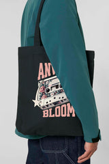 Schwarze Tote Bag mit retro-inspiriertem Design: Eine Kassette mit floralen Elementen, flankiert von zwei Sternen, und dem Schriftzug „ANWAY BLOOM“ in grossem rosa Vintage-Font – stylisch und nostalgisch zugleich.