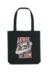 Schwarze Tote Bag mit retro-inspiriertem Design: Eine Kassette mit floralen Elementen, flankiert von zwei Sternen, und dem Schriftzug „ANWAY BLOOM“ in grossem rosa Vintage-Font – stylisch und nostalgisch zugleich.