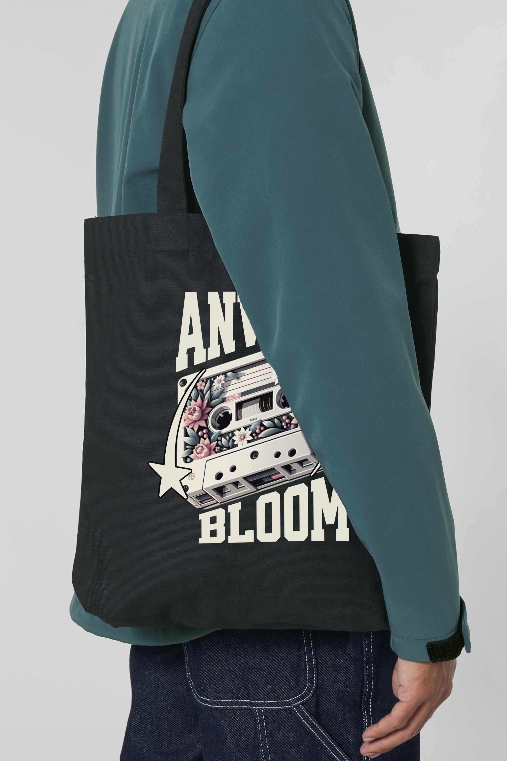Schwarze Tote Bag mit retro-inspiriertem Design: Eine Kassette mit floralen Elementen, flankiert von zwei Sternen, und dem Schriftzug „ANWAY BLOOM“ in grossem beigen Vintage-Font – stylisch und nostalgisch zugleich.