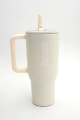 Grosser, wiederverwendbarer Trinkbecher in Beige („Cream“) mit transparentem Deckel und einklappbarem Silikonstrohhalm. Fassungsvermögen 1,12 Liter. Silikonboden für geräuschloses Abstellen. Ideal für unterwegs – hält Getränke lange warm oder kalt. 