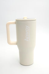 Grosser, wiederverwendbarer Trinkbecher in Beige („Cream“) mit transparentem Deckel und einklappbarem Silikonstrohhalm. Fassungsvermögen 1,12 Liter. Silikonboden für geräuschloses Abstellen. Ideal für unterwegs – hält Getränke lange warm oder kalt. 