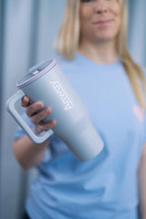 Grosser, wiederverwendbarer Trinkbecher in einem dezenten Hellblau („Frost“) mit transparentem Deckel und einklappbarem Silikonstrohhalm. Fassungsvermögen 1,12 Liter. Silikonboden für geräuschloses Abstellen. Ideal für unterwegs – hält Getränke lange warm oder kalt. 