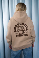 Moderner, oversized Unisex-Hoodie in Dark Beige aus kuschlig weicher Baumwolle mit einem Print auf der Rückseite.